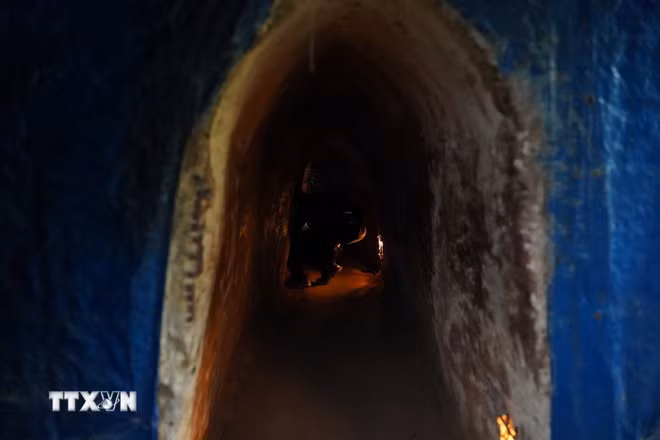 Khách tham quan phải cúi sát mặt đất mới có thể di chuyển được trong Địa đạo vì không gian rất nhỏ và tối. (Ảnh: Thu Hương/TTXVN)