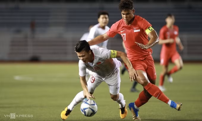 Nguyễn Quang Hải (áo trắng) trước khi chấn thương trong trận Việt Nam thắng Singapore 1-0 tại vòng bảng SEA Games 30, tại sân Rizal Memorial, Philippines, ngày 3/12/2019. Ảnh: Đức Đồng.