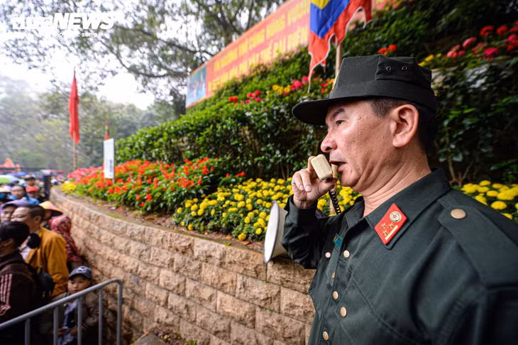 Lực lượng chức năng liên tục phát loa thông báo cho người dân, du khách xếp hàng theo quy định, phòng chống mất cắp.
