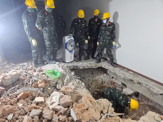 Lực lượng công binh tiếp cận nạn nhân chuẩn bị đưa thi thể ra ngoài, tử khí bao trùm hiện trường gây nhiều khó khăn cho việc cứu hộ. Ảnh: Song Hương