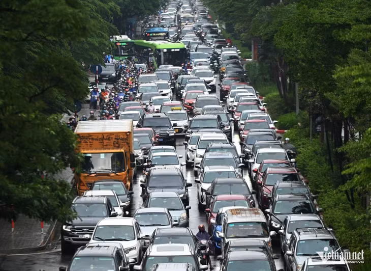Ô tô "dàn hàng ngang" đi sát vỉa hè khiến người đi xe máy buộc phải len lỏi, điền vào chỗ trống. Ảnh: Thạch Thảo