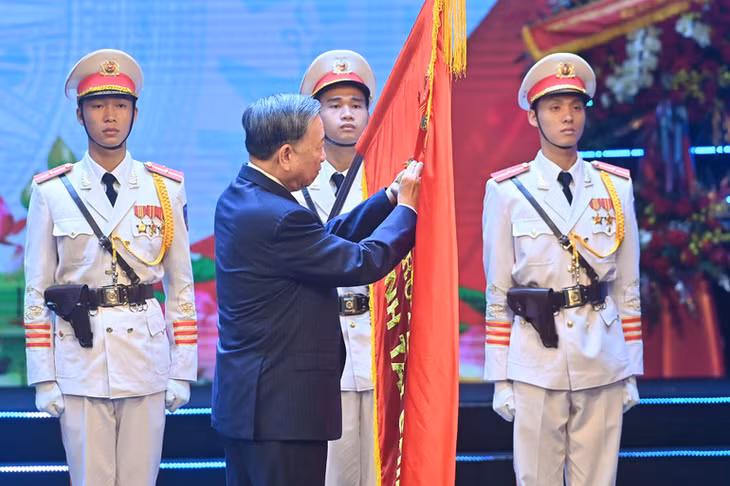 Tổng Bí thư Tô Lâm gắn Huân chương Độc lập hạng Nhất lên lá cờ truyền thống của ngành tài chính. (Ảnh: ĐĂNG KHOA)