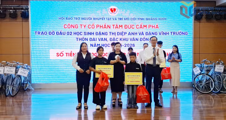 Chủ tịch HĐQT, Tổng Giám đốc Công ty CP Tâm Đắc Cẩm Phả Phạm Thị Cúc (giữa) cùng lãnh đạo Hội Bảo trợ NKT-TMC tỉnh và đại diện chính quyền thôn Đài Van (Đặc khu Vân Đồn) trao đỡ đầu cho 2 chị em ruột là Đặng Thị Diệp Anh và Đặng Vĩnh Trường (12 triệu đồng/em/năm).