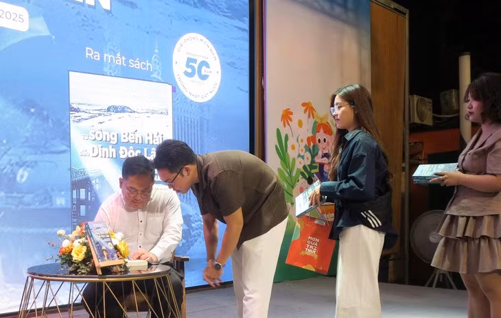 Ông Hoàng Nam Tiến ký tặng sách cho độc giả. Nhiều bạn trẻ rất thích những cuốn sách ông làm - Ảnh: T.T.D.