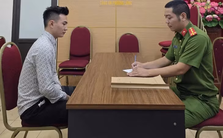 Nguyễn Xuân Khải (áo sơ mi xám) tại cơ quan công an - Ảnh: Công an cung cấp