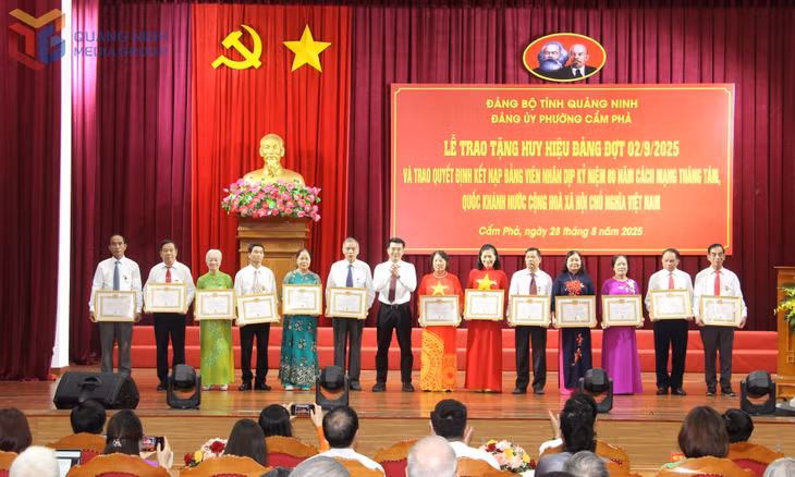 Đồng chí Hoàng Việt Dũng, Phó Bí thư Đảng ủy, Chủ tịch UBND phường Cẩm Phả, trao Huy hiệu Đảng cho các đồng chí 40 năm tuổi Đảng.