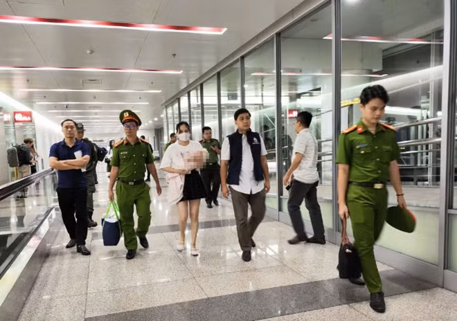 Lực lượng chức năng dẫn giải đối tượng truy nã Ngô Thị Thêu về Việt Nam. Ảnh: Bộ Công an