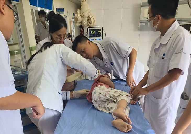 Lực lượng CSGT cùng người dân đưa cháu nhỏ đi cấp cứu. Ảnh: NDCC.