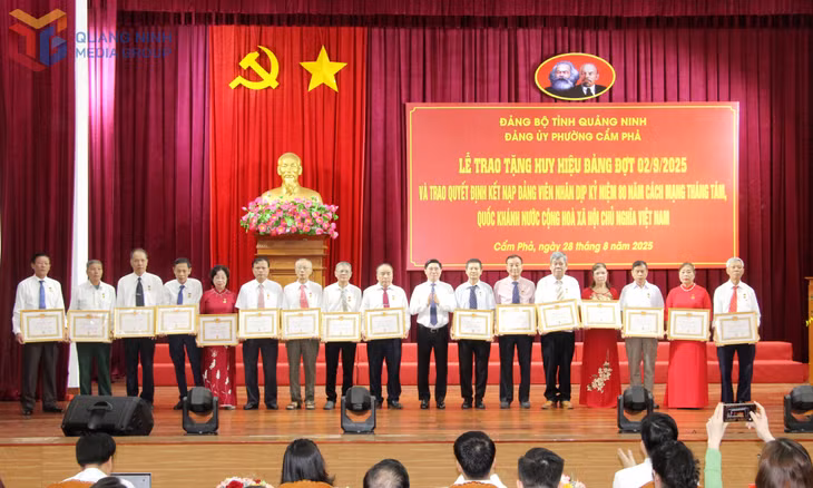 Đồng chí Vũ Hồng Chương, Phó Bí thư Thường trực Đảng ủy, Chủ tịch HĐND phường Cẩm Phả, trao Huy hiệu Đảng cho các đồng chí 40 năm tuổi đảng.