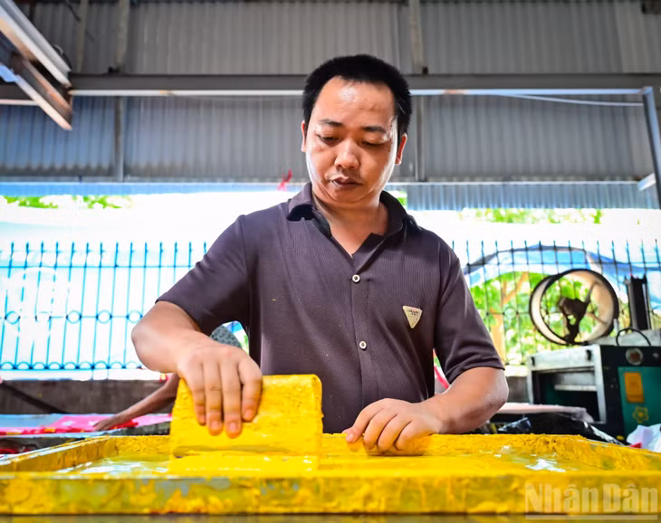 Người thợ lành nghề tập trung cao độ để hoàn thiện sản phẩm.