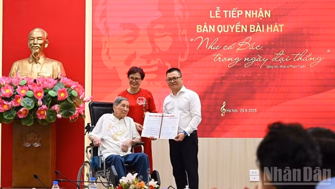 Tổng Biên tập Lê Quốc Minh nhận cuốn sổ ghi bài hát của nhạc sĩ Phạm Tuyên từ gia đình nhạc sĩ. Ảnh: THÀNH ĐẠT