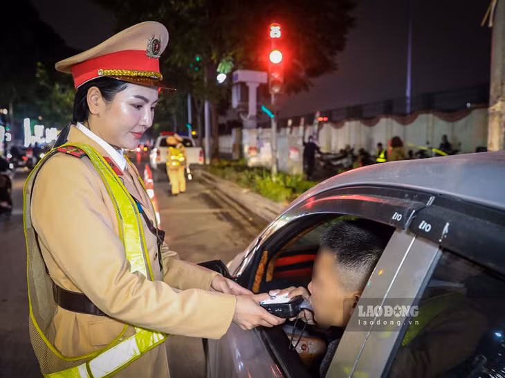 Thiếu tá Lê Thị Mai Ly thực hiện nhiệm vụ kiểm tra nồng độ cồn khi còn công tác tại Công an quận Thanh Xuân (tên gọi cũ). Ảnh: Tô Thế