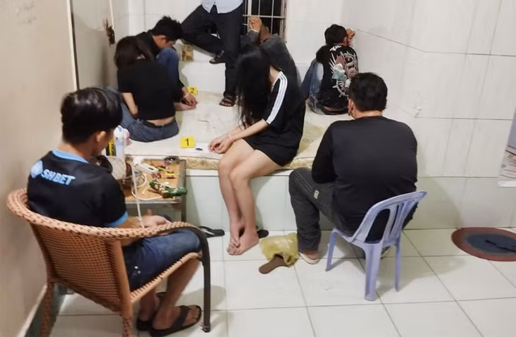 Nhóm đối tượng 11 nam, nữ bị bắt quả tang tổ chức và sử dụng trái phép chất ma túy. Ảnh: Vũ Tiến