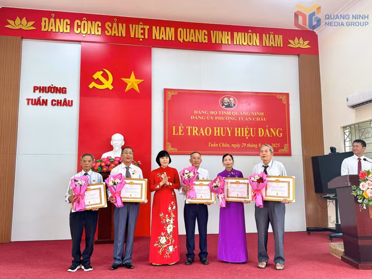 Đồng chí Bùi Thị Hương, Bí thư Đảng ủy, Chủ tịch HĐND phường Tuần Châu, trao Huy hiệu Đảng cho các đồng chí 45 năm tuổi Đảng.