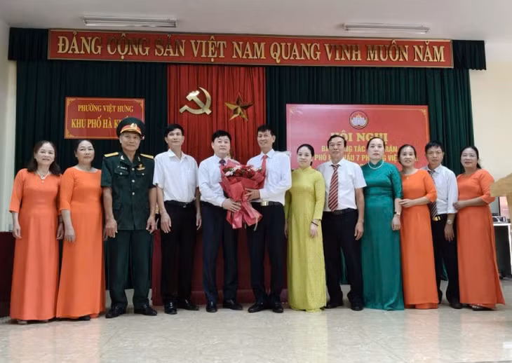 Đại diện phường Việt Hưng tặng hoa chúc mừng Ban công tác Mặt trận khu phố Hà Khẩu 7, nhiệm kỳ 2025-2028. Ảnh do đơn vị cung cấp