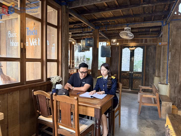 Cán bộ Thuế Cơ sở 1 hướng dẫn hộ kinh doanh ghi chép doanh thu. Ảnh: Cao Quỳnh