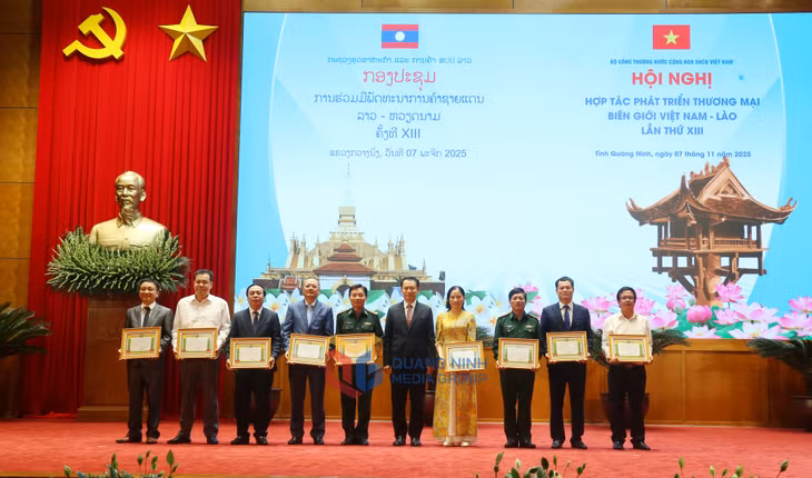 Đồng chí Mạ-lay-thong Côm-ma-sít, Ủy viên dự khuyết Trung ương Đảng, Bộ trưởng Bộ Công thương Lào, trao Bằng khen của Bộ Công thương Lào cho các tập thể có thành tích xuất sắc.