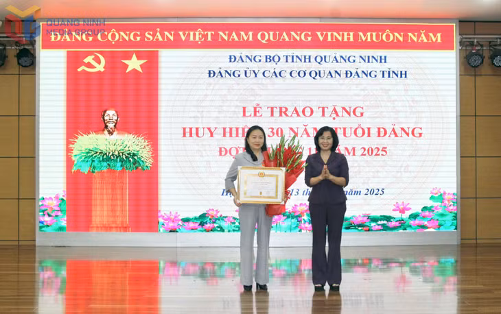 Đồng chí Trịnh Thị Minh Thanh, Phó Bí thư Thường trực Tỉnh ủy, Chủ tịch HĐND tỉnh, Bí thư Đảng ủy các cơ quan Đảng tỉnh trao huy hiệu 30 năm tuổi Đảng cho đồng chí Vi Ngọc Bích, Trưởng Ban Tổ chức Tỉnh ủy. 