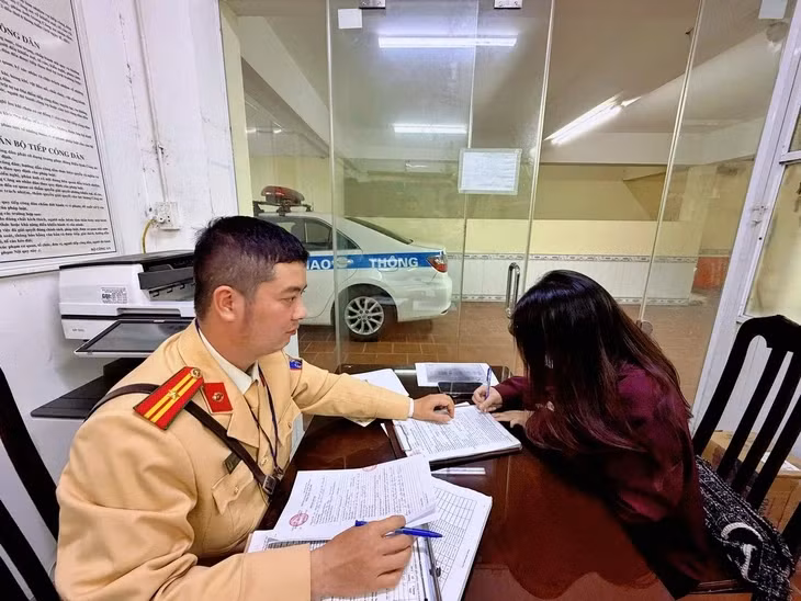 Nữ tài xế làm việc với cảnh sát giao thông - Ảnh: D.T.