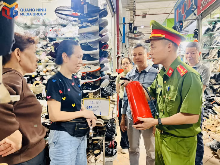 Bà Phạm Thị Hợp (thứ 2 từ trái sang) và các tiểu thương được hướng dẫn cách sử dụng bình chữa cháy.