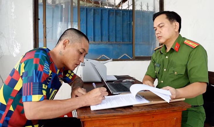 Bị can Võ Văn Phút ký nhận các quyết định và lệnh tạm giam. Ảnh: Vũ Tiến