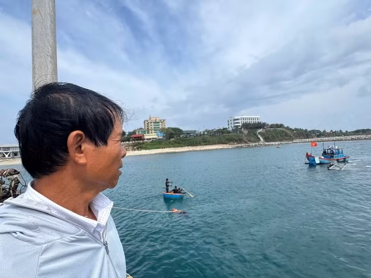 Ông Thành nhìn về chiếc tàu của mình đã nằm dưới đáy biển - Ảnh: LÊ TRUNG
