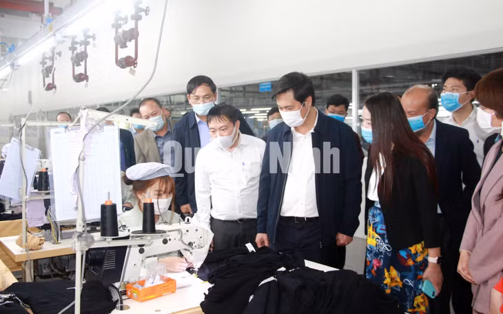 Chủ tịch UBND tỉnh Nguyễn Tường Văn thăm hỏi, động viên các công nhân đang trực tiếp lao động tại Công ty TNHH May mặc Hoa Lợi Đạt (2-2021). Ảnh: Mạnh Trường