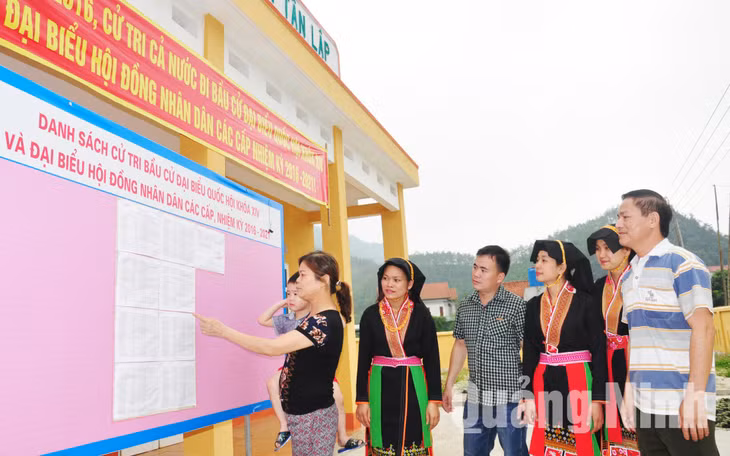 Cử tri thôn Tân Lập, xã Tân Dân, huyện Hoành Bồ kiểm tra danh sách cử tri được niêm yết tại nhà văn hóa thôn. Ảnh: Ngọc Hà