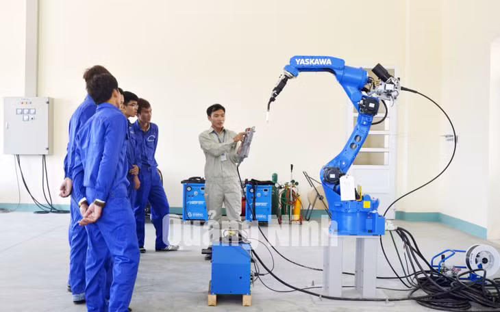 Giáo viên hướng dẫn sinh viên thực hành sử dụng robot hàn tự động. Ảnh: Phương Thúy