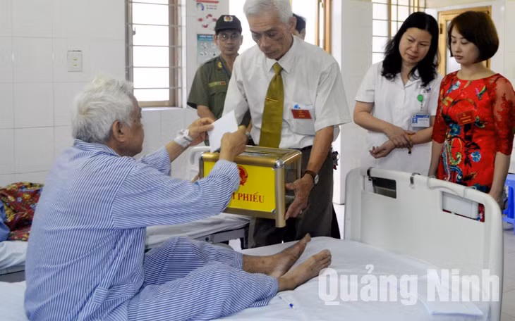 Các thành viên Tổ Bầu cử số 4, phường Bạch Đằng (TP Hạ Long) đưa hòm phiếu lưu động tới Bệnh viện Đa khoa tỉnh để cử tri thực hiện quyền bầu cử tại phòng bệnh. Ảnh: Hoàng Quý