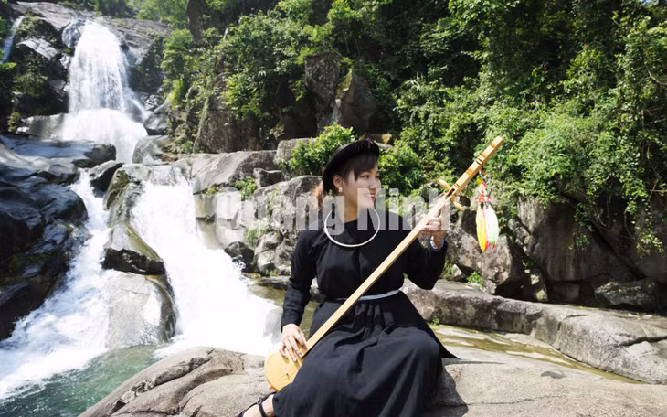 Thiếu nữ Tày hát then bên thác Khe Vằn (huyện Bình Liêu) (7-2014). Ảnh: Khánh Giang