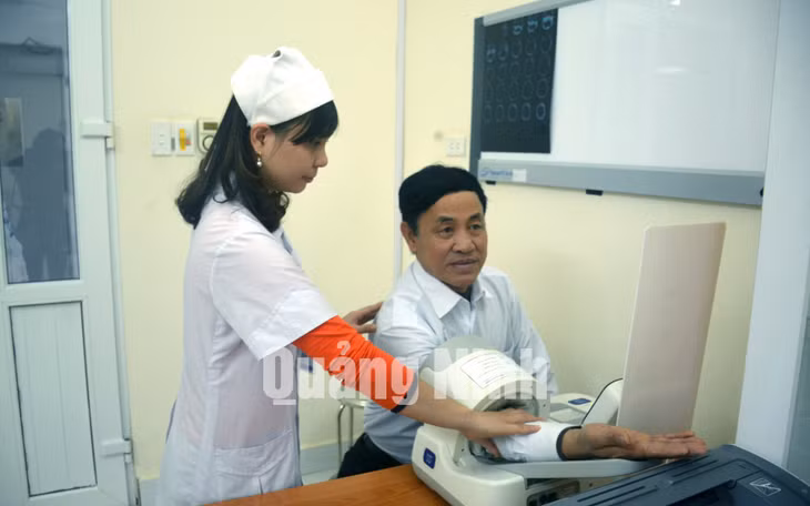 Nhân viên y tế Trung tâm Y tế TX Quảng Yên đo huyết áp cho người bệnh (12-2017). Ảnh: Nguyễn Hoa