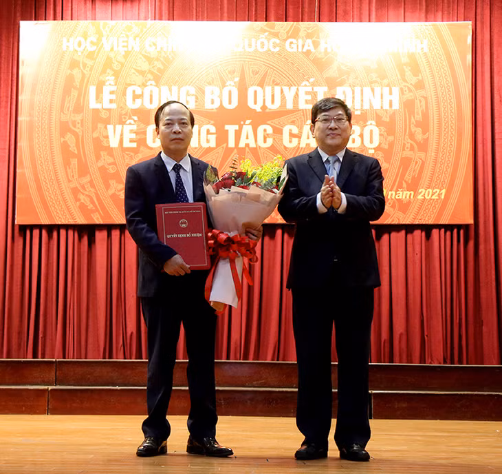 PGS,TS. Nguyễn Duy Bắc, Phó Bí thư Đảng ủy, Phó Giám đốc Học viện Chính trị quốc gia Hồ Chí Minh trao quyết định và tặng hoa chúc mừng PGS,TS. Mai Đức Ngọc, Bí thư Đảng ủy Học viện Báo chí và Tuyên truyền giữ chức vụ Chủ tịch Hội đồng trường nhiệm kỳ 2018-2023