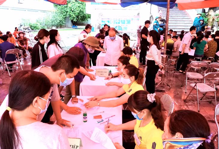 Các thành viên tổ Covid-19 cộng đồng phường Cẩm Sơn, TP Cẩm Phả giúp người dân khai báo và bảo vệ trật tự khu vực người dân tiêm phòng mũi 2 phòng chống chống dịch