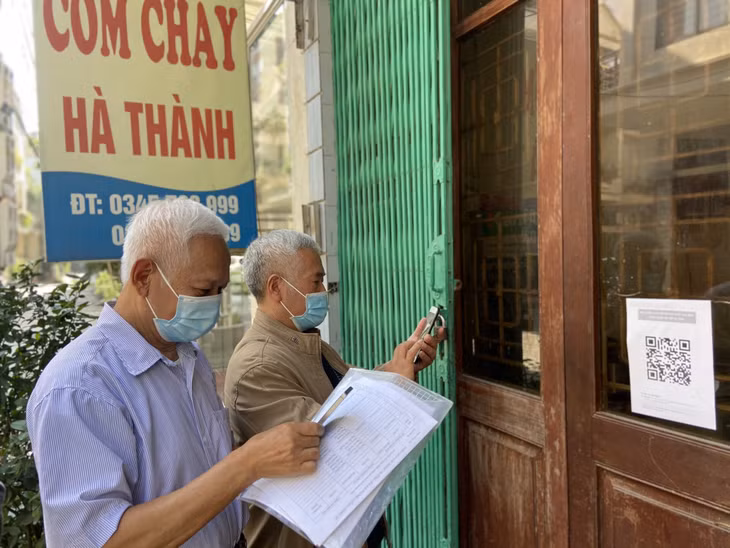 Ông Ngô Quang Hiên, Bí thư Chi bộ, Khu trưởng khu 4 (phố Hải Long, phường Hồng Hải) cùng với ông Bùi Đức Biên, Tổ trưởng Tổ liên gia trong khu phố kiểm tra việc dán mã quét QR của các nhà hàng.