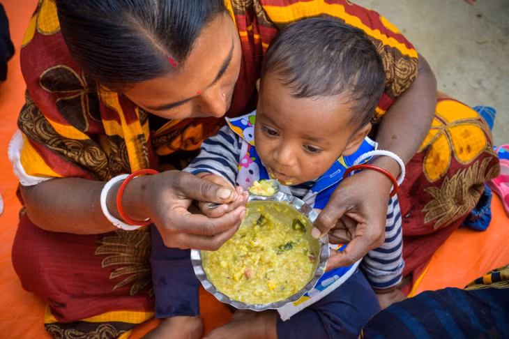 Bà mẹ cho con ăn cháo tại làng Tildanga, Bangladesh, nơi 27% trẻ dưới 5 tuổi bị còi cọc. Ảnh: World Vision