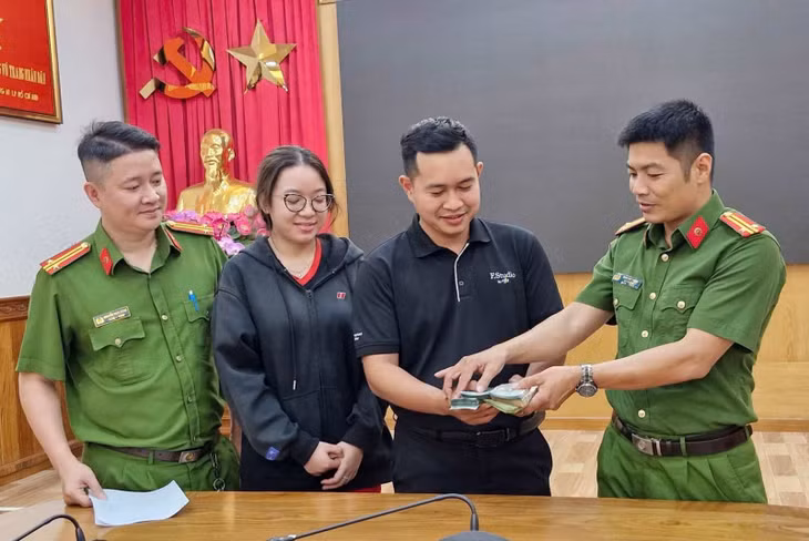 Đại diện Phòng Cảnh sát hình sự bàn giao lại toàn bộ số tiền tang vật bị cướp cho đại diện cửa hàng FPT shop.