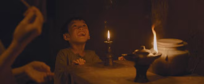 Cậu bé Lĩnh (trong truyện gốc là Đản) và ngọn đèn kỳ quái trong phim. (Ảnh từ phim)
