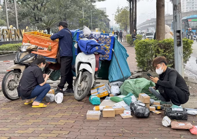 Shipper chờ khách nhận hàng tại phố Duy Tân, Cầu Giấy, Hà Nội vào tháng 2/2024. Ảnh: Ngọc Thành