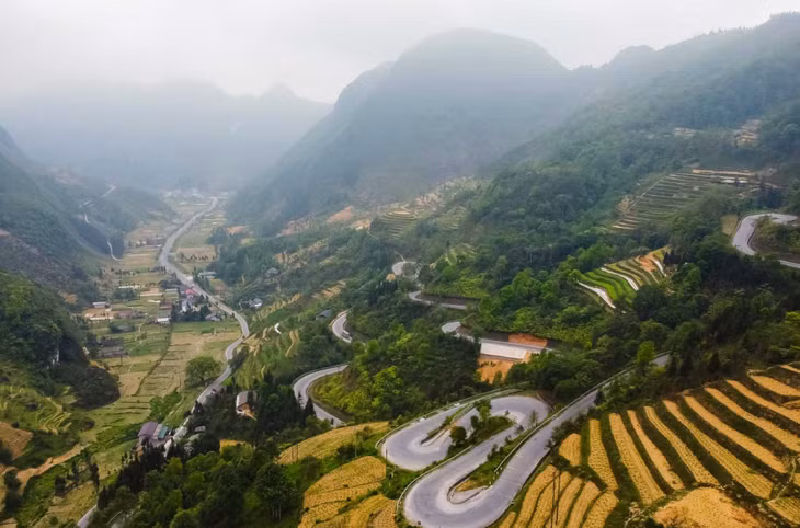 Từ đường đèo nhìn xuống, du khách sẽ thấy những thửa ruộng bậc thang trải theo sườn núi, những mái nhà lấp ló dưới thung lũng. Ảnh: Hà Giang Trẻ