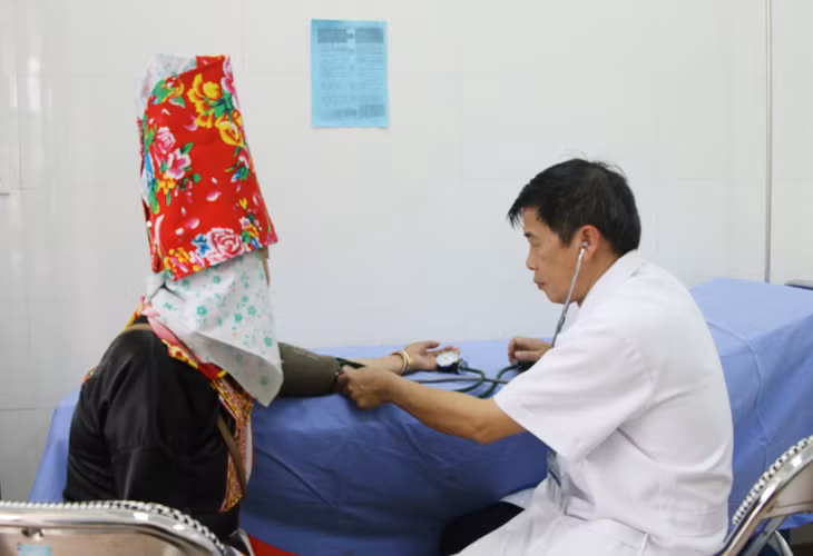 Bác sĩ Vi Văn Nồng, Trưởng Trạm Y tế xã Đồng Văn, khám bệnh cho người dân.