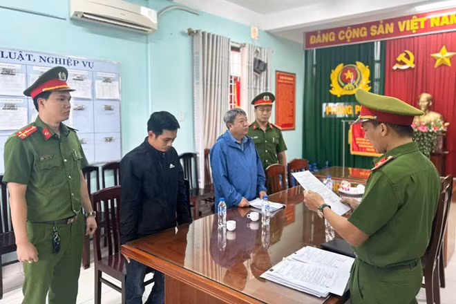 Cơ quan CSĐT Công an tỉnh Bình Định thi hành lệnh bắt tạm giam bị can Trần Ngọc Hiền - nguyên Chủ tịch UBND phường Nhơn Bình và bị can Nguyễn Văn Luôn - nguyên cán bộ địa chính phường Nhơn Bình. Ảnh: Kiều Anh