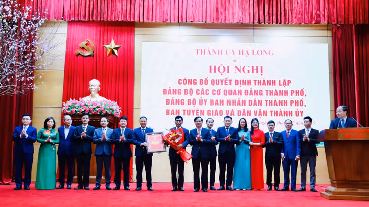 Đồng chí Vũ Quyết Tiến, Ủy viên Ban Thường vụ Tỉnh ủy, Bí thư Thành ủy Hạ Long trao Quyết định và tặng hoa chúc mừng Đảng bộ UBND thành phố.