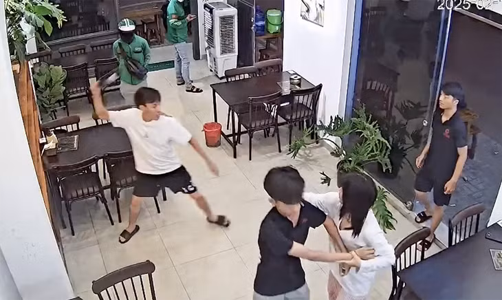 P. cầm chai rượu vang trong quán, ném bể cửa kính cường lực. Ảnh: Cắt từ clip
