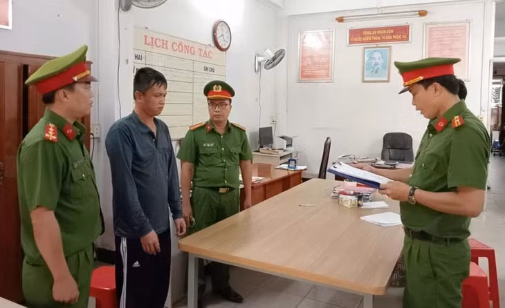 Công an tống đạt quyết định khởi tố, bắt tạm giam Trần Duy Đệ. Ảnh: CA
