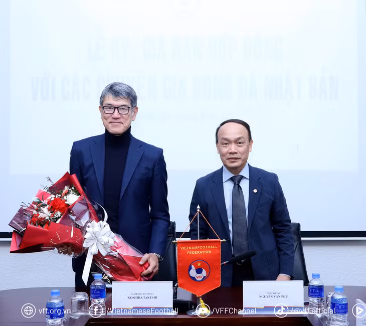 Giám đốc kỹ thuật Koshida Takeshi (trái) nhận hoa chúc mừng sau khi tái ký hợp đồng - Ảnh: VFF