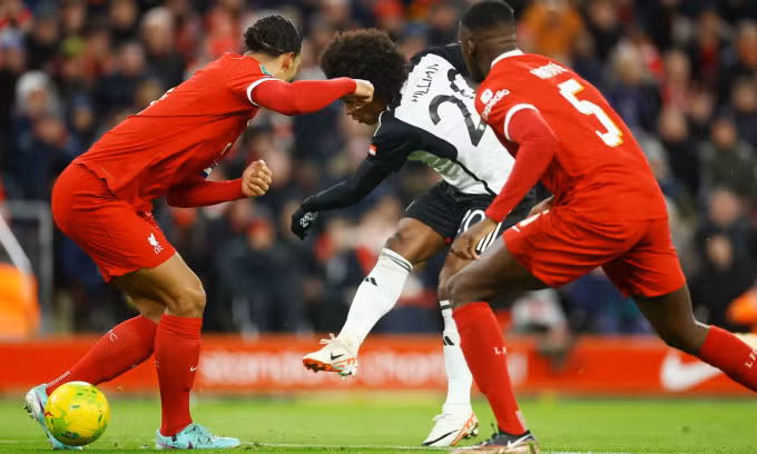 Tình huống Willian sút qua hai chân Van Dijk để mở tỷ số cho Fulham trên sân Anfield, thành phố Liverpool, Anh, ở bán kết lượt đi Cup Liên đoàn tối 10/1/2024. Ảnh: Reuters