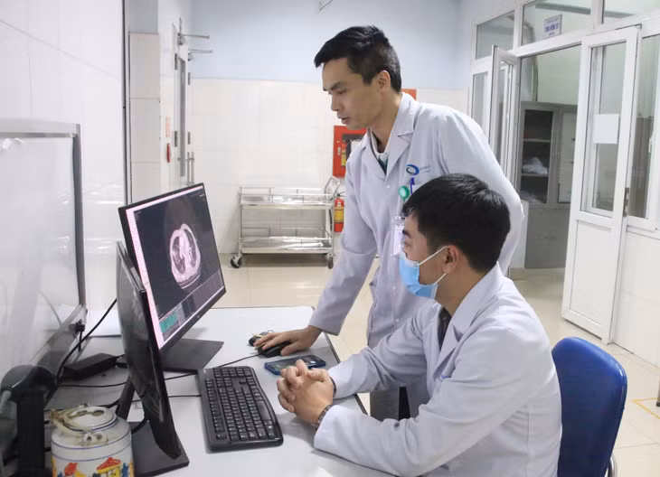 Bác sĩ Lê Tiến Hưng (người đứng) hướng dẫn chuyên môn cho bác sĩ trẻ trong khoa.