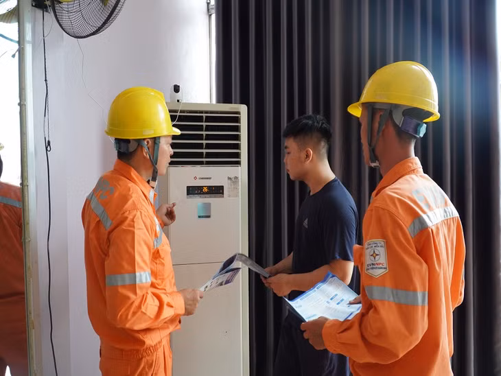 Công nhân Điện lực TP Móng Cái hướng dẫn khách hàng sử dụng điện tiết kiệm và hiệu quả.