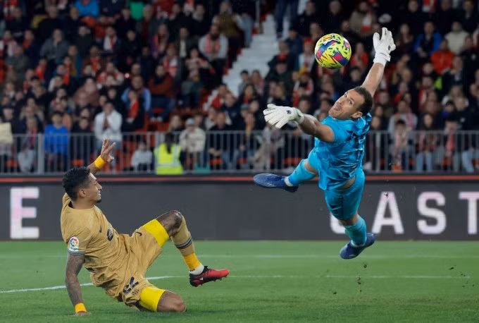 Raphinha (trái) trong một pha dứt điểm bất thành trước thủ môn Martinez của Almeria. Ảnh: Reuters